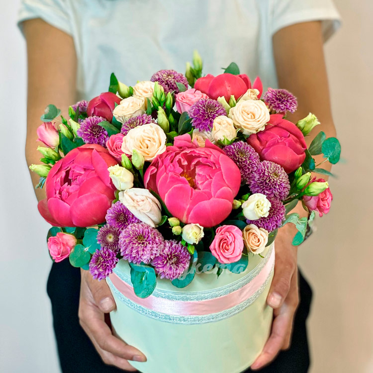 Коралловые пионы и хризантемы в коробке (в руках флориста)