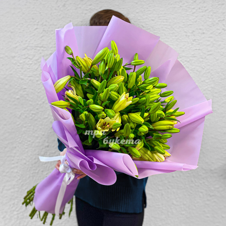 Яркий букет высоких белых лилий (в руках флориста)